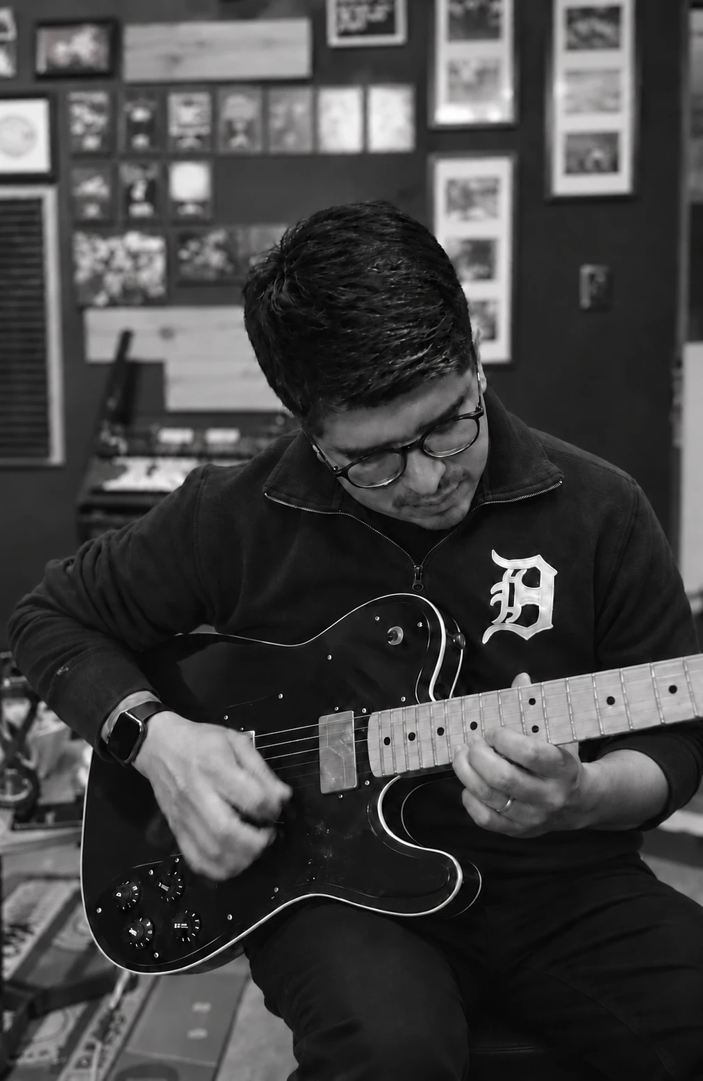 Martín Beas tocando una guitarra eléctrica negra en un estudio, en blanco y negro.